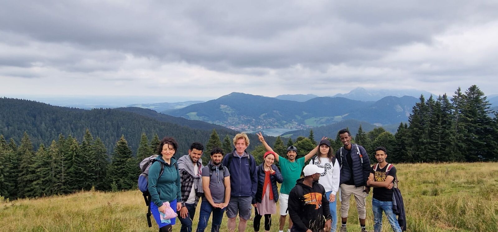 Hier sieht man ein Gruppenbild von wandernden Personen in den Bergen.