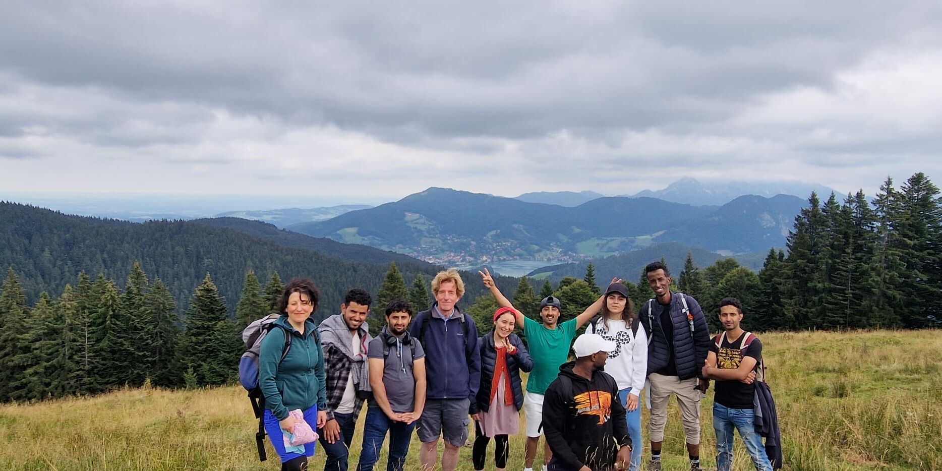 Hier sieht man ein Gruppenbild von wandernden Personen in den Bergen.